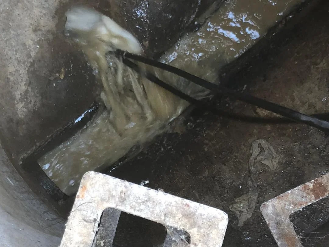 Inspection chamber being cleared by drain jetting