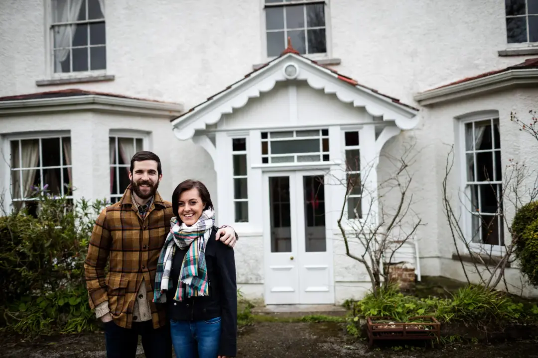 Couple standing outside a period house they are buying